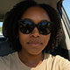 Woman wearing sunglasses taking selfie inside her car